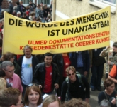 Menschen tragen einen Banner mit der Aufschrift "Die Würde des Menschen ist unantastbar"